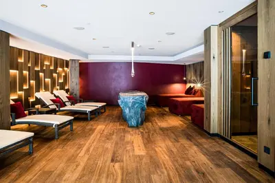 a hotel lobby with a couch and a table at Granbaita Dolomites in Selva di Val Gardena