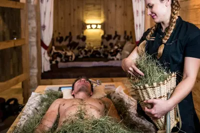 a woman standing next to a man laying on a table at Granbaita Dolomites in Selva di Val Gardena