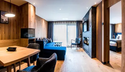 a living room with a blue couch and a table at Granbaita Dolomites in Selva di Val Gardena