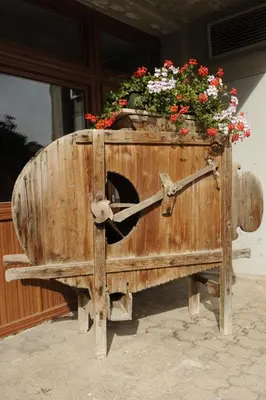 a wooden barrel with flowers on top of it at Alpine Touring Hotel-petfriendly in Pozza di Fassa