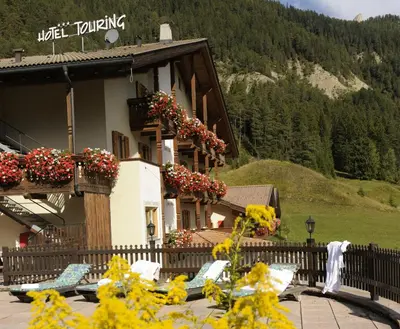 a building with flowers on the side of it at Alpine Touring Hotel-petfriendly in Pozza di Fassa