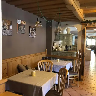 a dining room with two tables and a kitchen at Alpine Touring Hotel-petfriendly in Pozza di Fassa