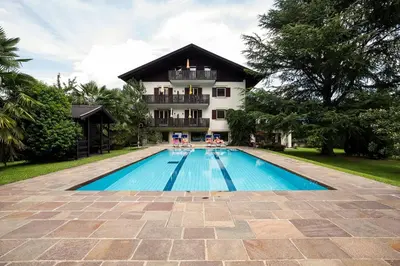 an image of a swimming pool in front of a house at Apartments Obermayr in Lana