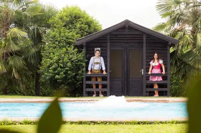 a man and woman standing in a doghouse by a pool at Apartments Obermayr in Lana