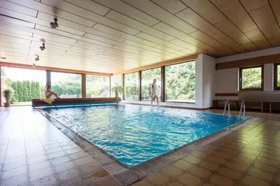 a large swimming pool in a room with windows at Apartments Feyerlin in Lana