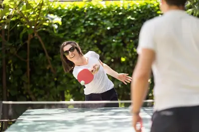 a woman playing with a ball in a swimming pool at Apartments Feyerlin in Lana