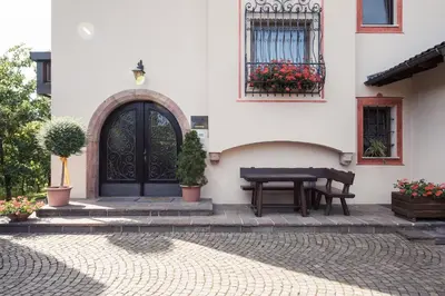 a house with a black door and a table at Apartments Feyerlin in Lana