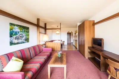 a living room with a couch and a tv at Apartments Feyerlin in Lana
