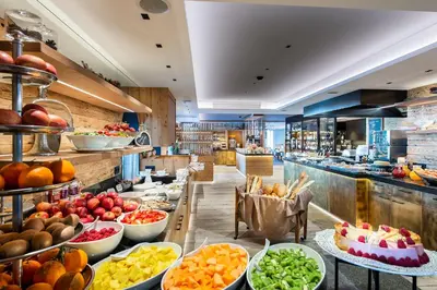 a buffet line with fruits and vegetables on display at Hotel Albion Mountain Spa Resort Dolomites in Ortisei