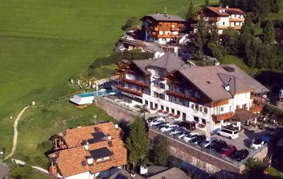 an aerial view of a large house with a parking lot at Hotel Interski in Santa Cristina in Val Gardena