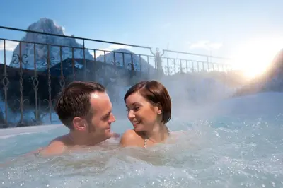 a man and a woman in a hot tub at Hotel Interski in Santa Cristina in Val Gardena