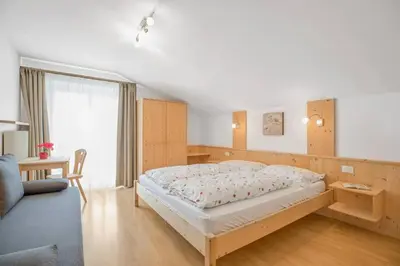 a bedroom with a bed and a couch at Residence krUma in Valdaora