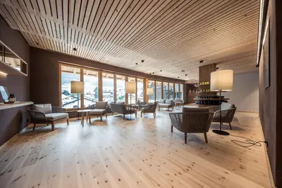 a large room with chairs and tables and windows at Hotel Lamm in Castelrotto