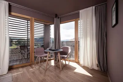 a room with a table and chairs and a large window at Hotel Lamm in Castelrotto