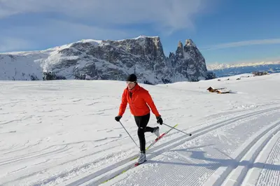 a woman is cross country skiing in the snow at Hotel Lamm in Castelrotto