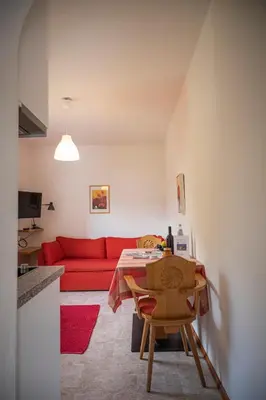 a living room with a red couch and a table at Villa Ladurner in Tirolo