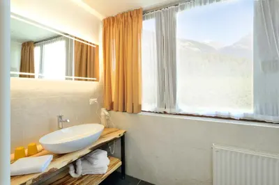 a bathroom with a sink and a large window at Hotel Flötscherhof in Naz-Sciaves