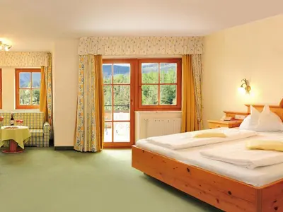 a bedroom with a large bed and a window at Hotel Flötscherhof in Naz-Sciaves