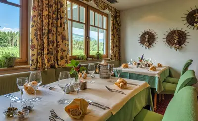 a dining room with two tables and windows at Hotel Flötscherhof in Naz-Sciaves