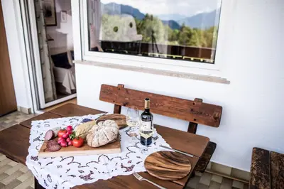 a table with a plate of food and a bottle of wine at Apartment Matilde in Vols am Schlern