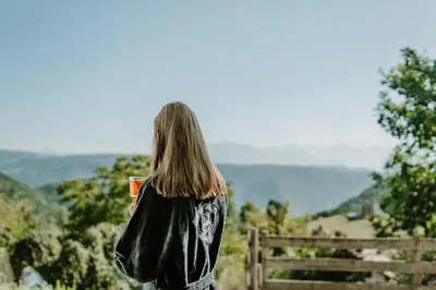 a woman standing on a hill looking at the view at Hotel & Gasthof zum Hirschen in San Genesio Atesino