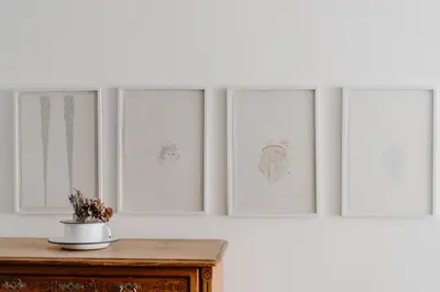 a table with four paintings on a white wall at Hotel & Gasthof zum Hirschen in San Genesio Atesino