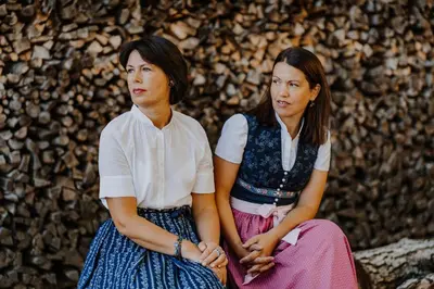 two young women sitting next to each other at Hotel & Gasthof zum Hirschen in San Genesio Atesino