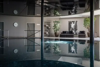 a living room with a swimming pool in a building at Hotel Patrizia in Tirolo