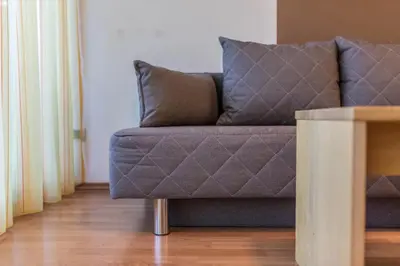a couch sitting in a living room next to a table at Appartements Durnbrunn in Valdaora