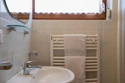 a bathroom with a sink and a window and towels at Appartements Durnbrunn in Valdaora