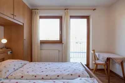 a bedroom with a bed and a desk and a window at Appartements Durnbrunn in Valdaora