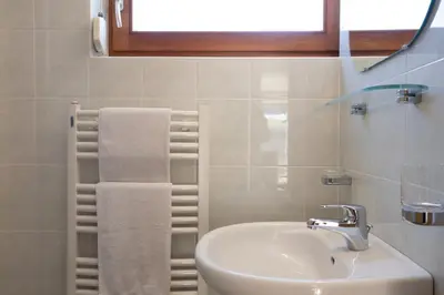 a white bathroom with a sink and a window at Appartements Durnbrunn in Valdaora