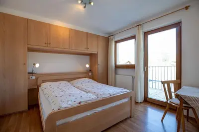 a bedroom with a bed and a large window at Appartements Durnbrunn in Valdaora