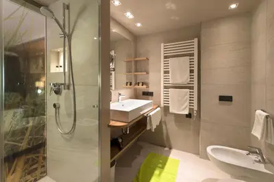 a bathroom with a shower and a sink and a shower at Hotel Grien in Ortisei