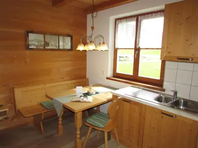 a kitchen with wooden walls and a table and a sink at Stifterhof in Villabassa