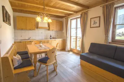 a kitchen and dining room with a table and a couch at Stifterhof in Villabassa