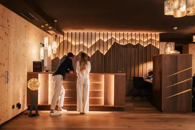 a man and a woman standing at a counter at Hotel La Majun in La Villa