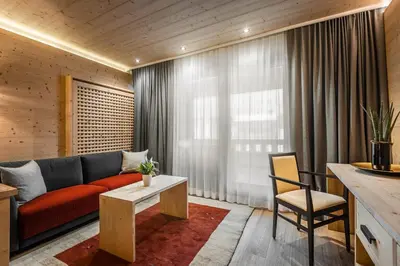 a large bedroom with a large bed and a red bench at Hotel La Majun in La Villa