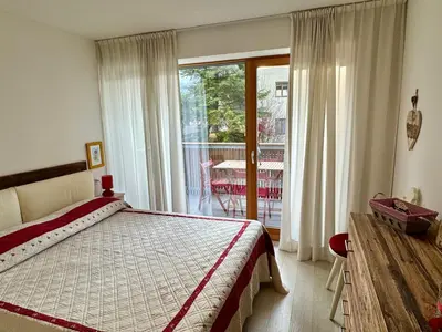 a bedroom with a bed and a sliding glass door at Da Renata in Valdaora