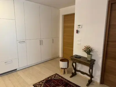 a room with white cabinets and a table with a chair at Da Renata in Valdaora