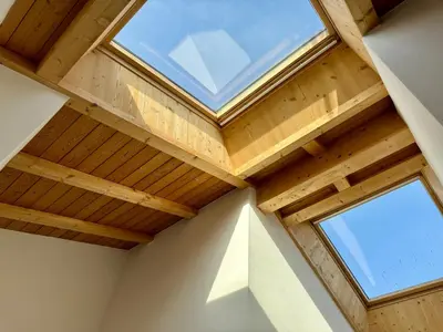 a room with a wooden ceiling with a window at Da Renata in Valdaora