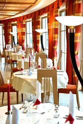 a restaurant with white tables and chairs and red curtains at Hotel Chalet Tianes - Alpine Relax in Castelrotto