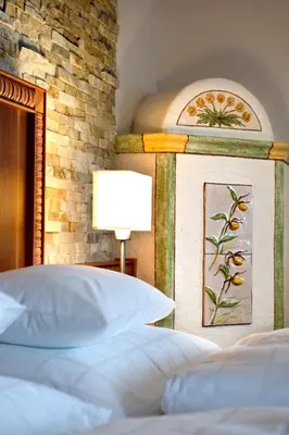 a bedroom with a bed with a painting on the wall at Hotel Chalet Tianes - Alpine Relax in Castelrotto