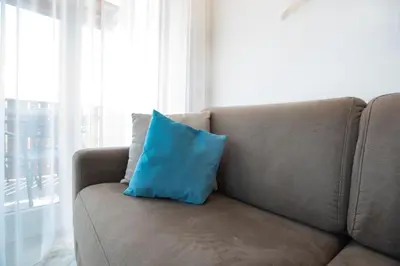 a blue pillow sitting on a couch next to a window at Gutshof Rellich in Termeno
