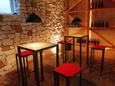 a row of stools in a room with a stone wall at Gutshof Rellich in Termeno