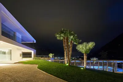 two palm trees in front of a house at night at The View Luxury Suites in Lagundo