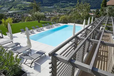a large swimming pool with chairs and avisorvisor at The View Luxury Suites in Lagundo