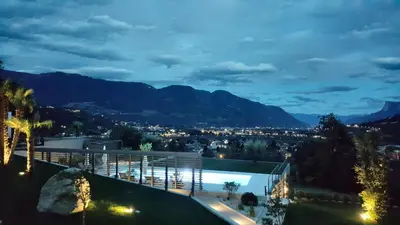 a villa with a view of the mountains at night at The View Luxury Suites in Lagundo