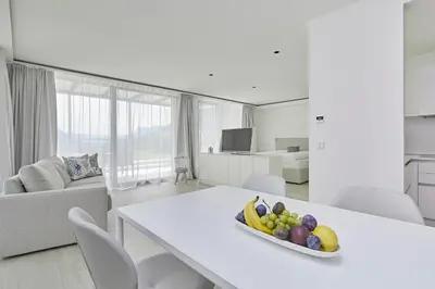 a white living room with a table with a bowl of fruit at The View Luxury Suites in Lagundo