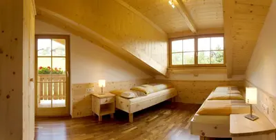 a bedroom with two beds in a wooden house at Obermoserhof in Feldthurns